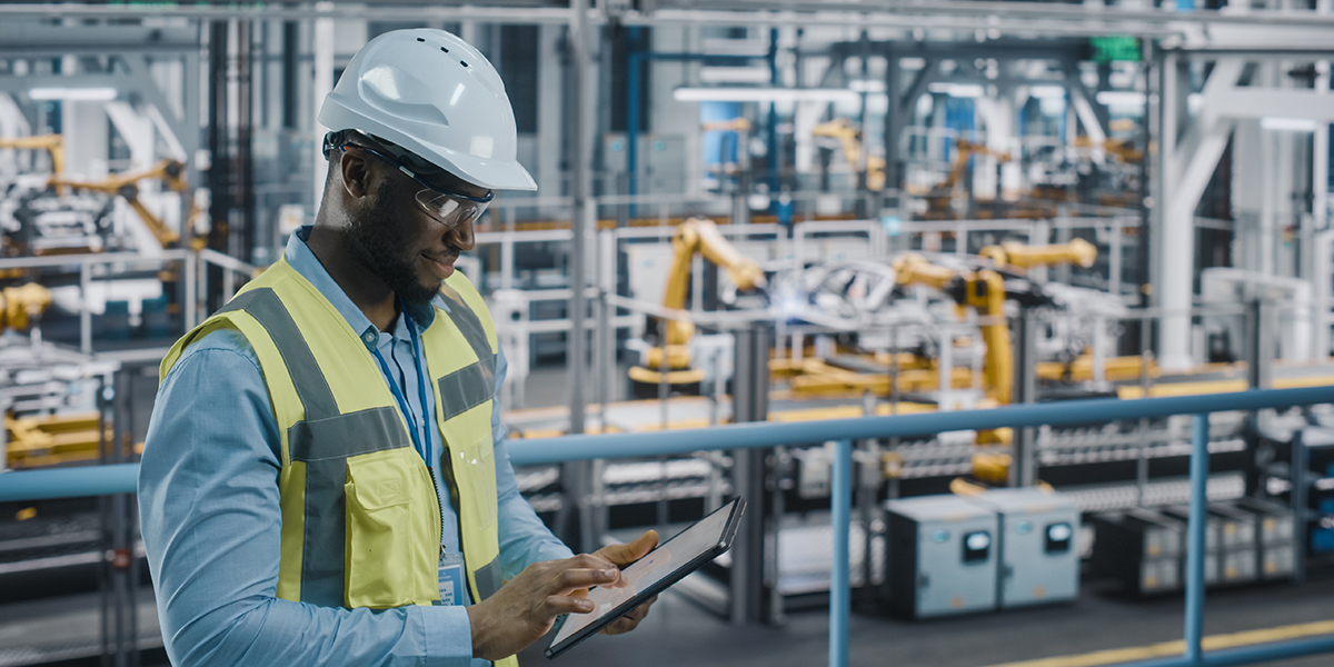 Industrial professional using digital procurement platform on tablet in manufacturing facility